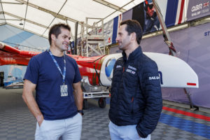 Ben Ainslie, driver of Emirates Great Britain SailGP Team, speaks with VIP guest Richie McCaw, former New Zealand rugby team captain, in front of the Emirates Great Britain SailGP Team F50 catamaran.